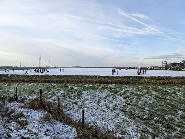 People playing ice hockey and ice skating near the River Nene