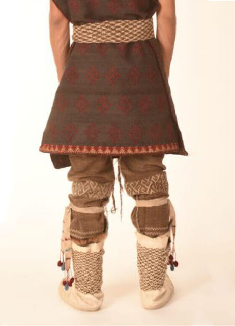 A model wears a woven recreation of Turfan Man's outfit, which includes a belted poncho, pants with braided leg fasteners, and boots. M. WAGNER et al./ASIA ARCHAEOLOGICAL RESEARCH 2022
