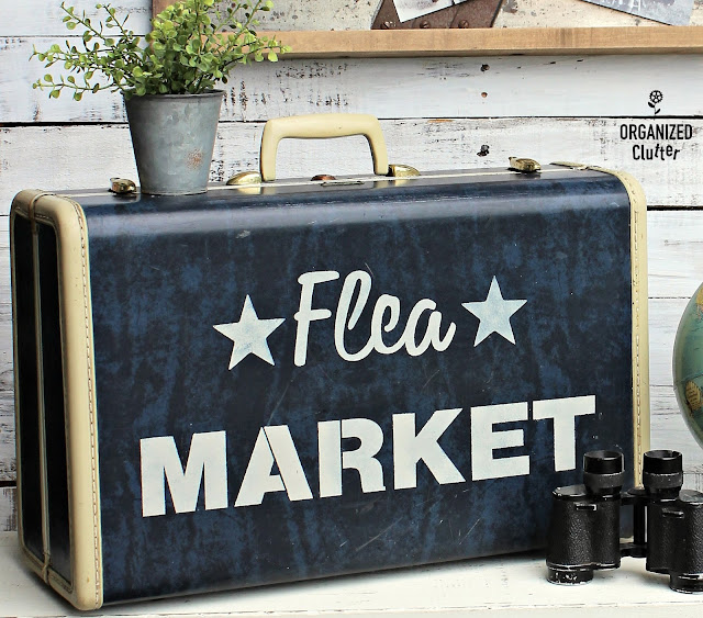 Photo of a vintage suitcase stenciled with Flea Market.