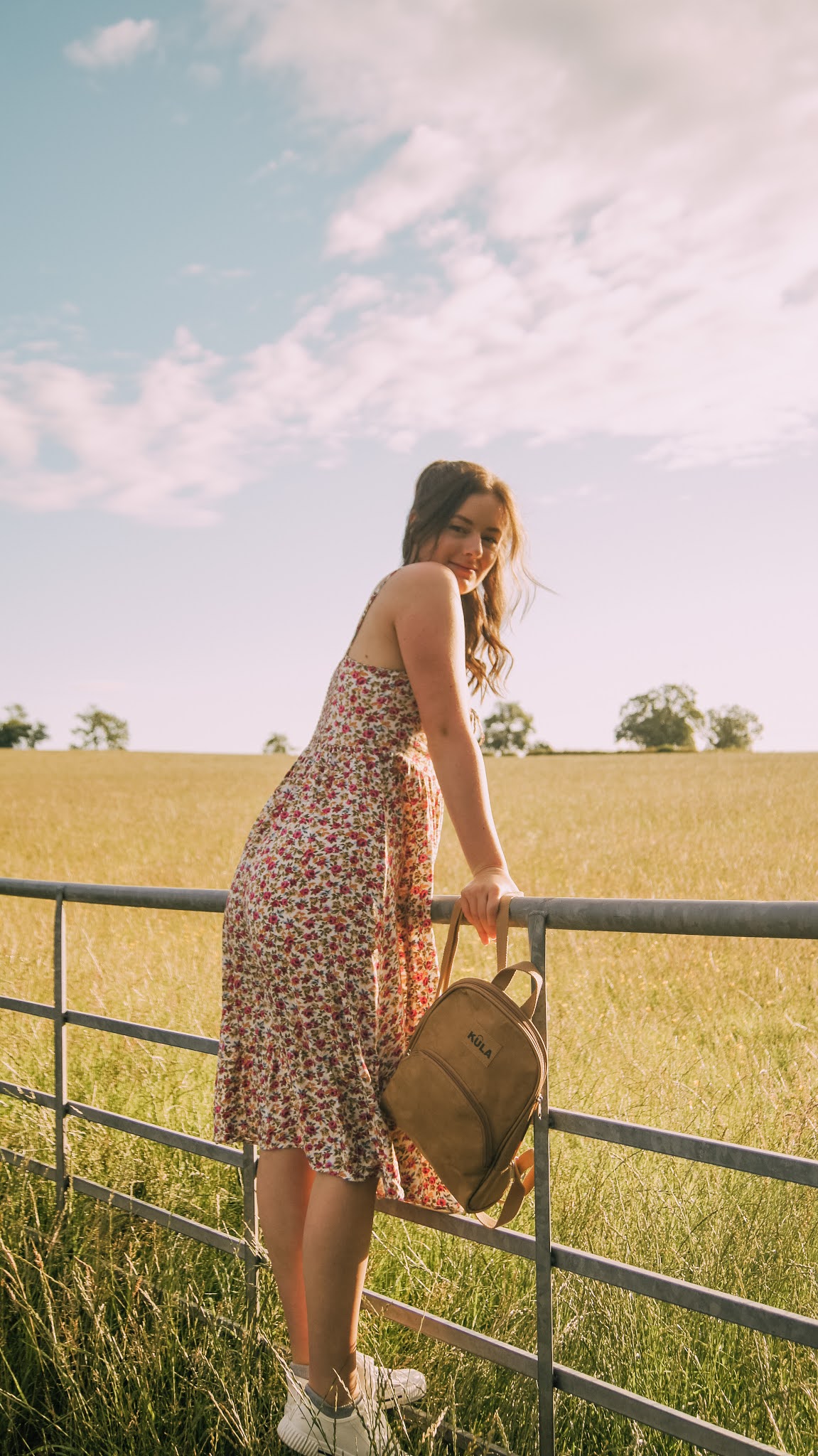 girl standing on gate with Kula backpack