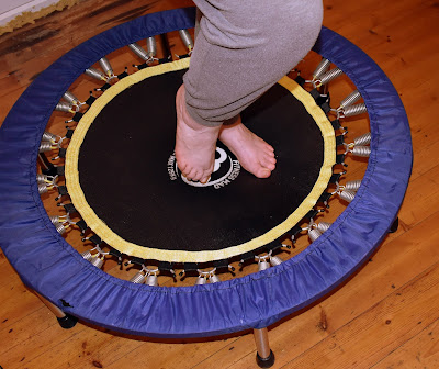 woman standing on rebounder to show size of exercise equipment