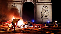 A protester burns a barricade during "yellow vest" riots this month against a gas-tax hike in France. (Credit: Benoit Tessier / Reuters) Click to Enlarge.