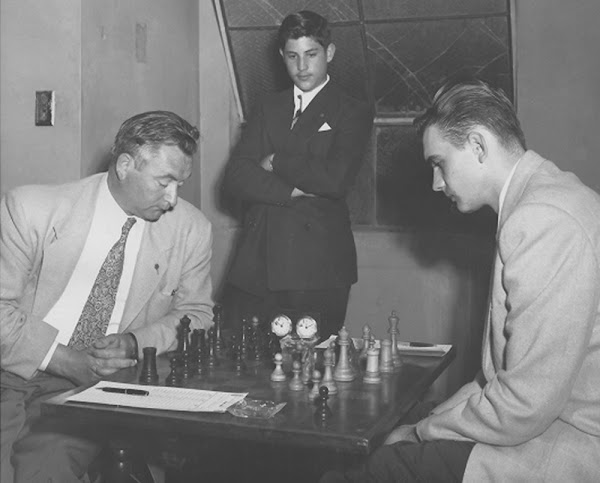 Eugene Steiner observes while James Cross (playing white) and Vladimir Pafnutieff study their moves in a 1952 Hollywood International. Photo by Nancy Roos.