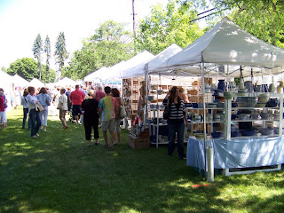 Artists booths and tents at the fair. Showing a sunny bright day and lots of people