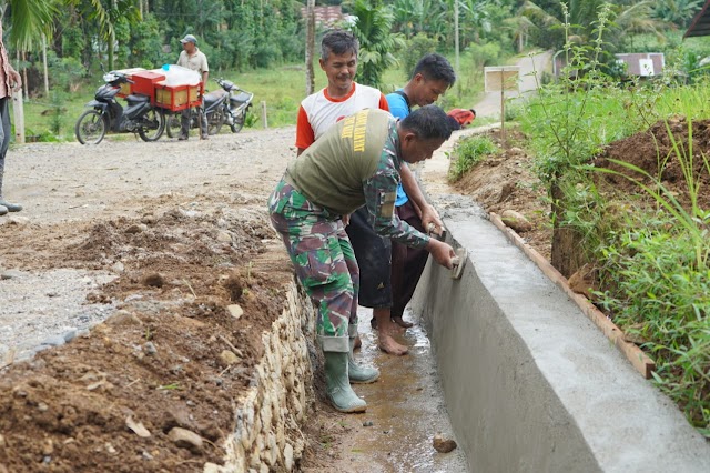 Cegah Genangan Air Satgas TMMD dan Warga Plaster Parit Jalan