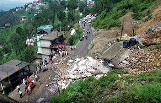 People looking at the rubbles of the two houses that collapsed due to heavy rains in Shimla on Monda