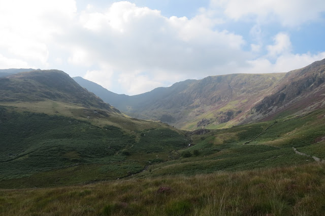 In sunlight, the glacial valley and summit ridge above it.