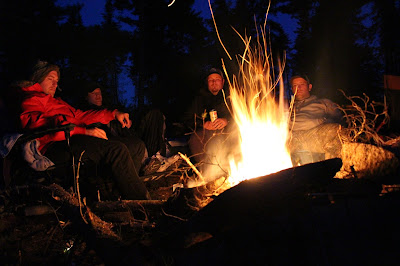 The boys sitting around the campfire