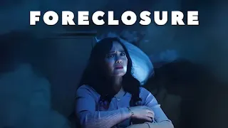 Perempuan berambut panjang duduk ketakutan di lantai, bersandar di lemari dengan suasana kabut gelap, tulisan "Foreclosure".