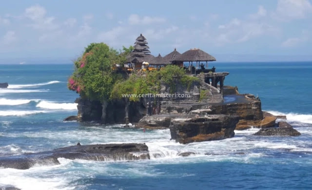Tanah Lot Temple in Bali, perched on a rocky outcrop above the sea with waves crashing beneath it