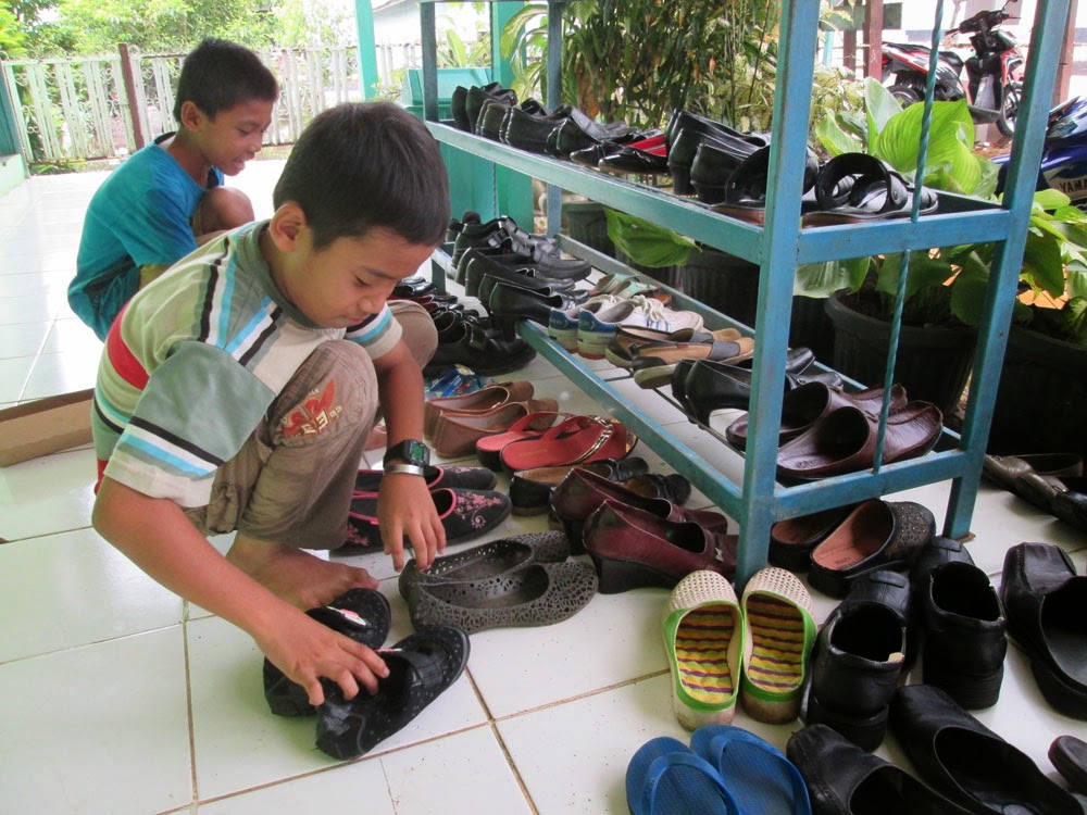 Faisal Rapikan Sepatu Para Tamu