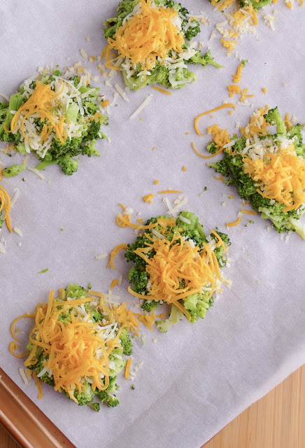 unbaked broccoli bites on a parchment lined copper colored baking sheet.