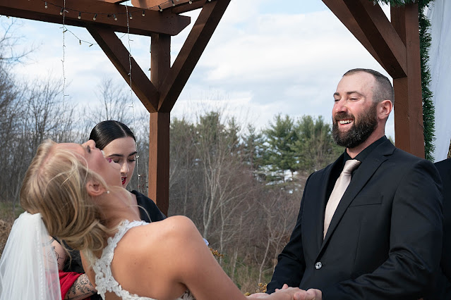 Candid of Bride bending backwards laughing and Groom smiling at the alter during ceremony Magnolia Farm Asheville Wedding Photography captured by Houghton Photography