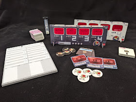 The components: two cardboard standees with red cellophane windows, one black and one white. A stack of cards with red markings on them to obscure the blue text; when these cards are slid into the display stands, the text becomes visible. There are also two stacks of cards that resemble 5 ¼ inch floppy disks, one in white and one in black. There are four black tokens, four white tokens, a sand timer, and a pad of scoresheets.
