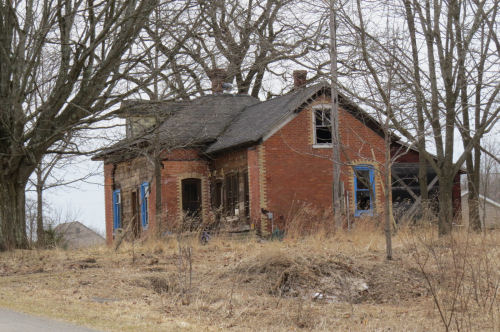 dilapidated brick house with quoins