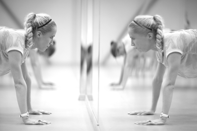 Women doing push-ups in front of the mirror, monochrome