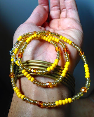 Simboli del sacerdozio di Oshun: collana gialla e braccialetti di ottone