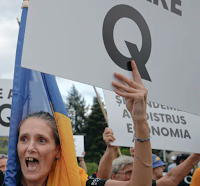 Romanian supporters of the QAnon conspiracy theories shout slogans against the government’s measures to prevent the spread of COVID-19 infections, like wearing a face mask, during a rally in Bucharest in August. (AP Photo/Vadim Ghirda)