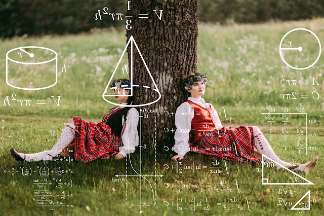 two latvian girls in traditional folk costumes sitting under a tree and thinking