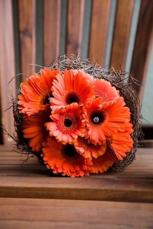 A lighter orange gerber daisy bouquet with orange roses