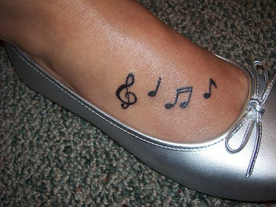 tattoos of lilies on feet. tattoos of music notes.