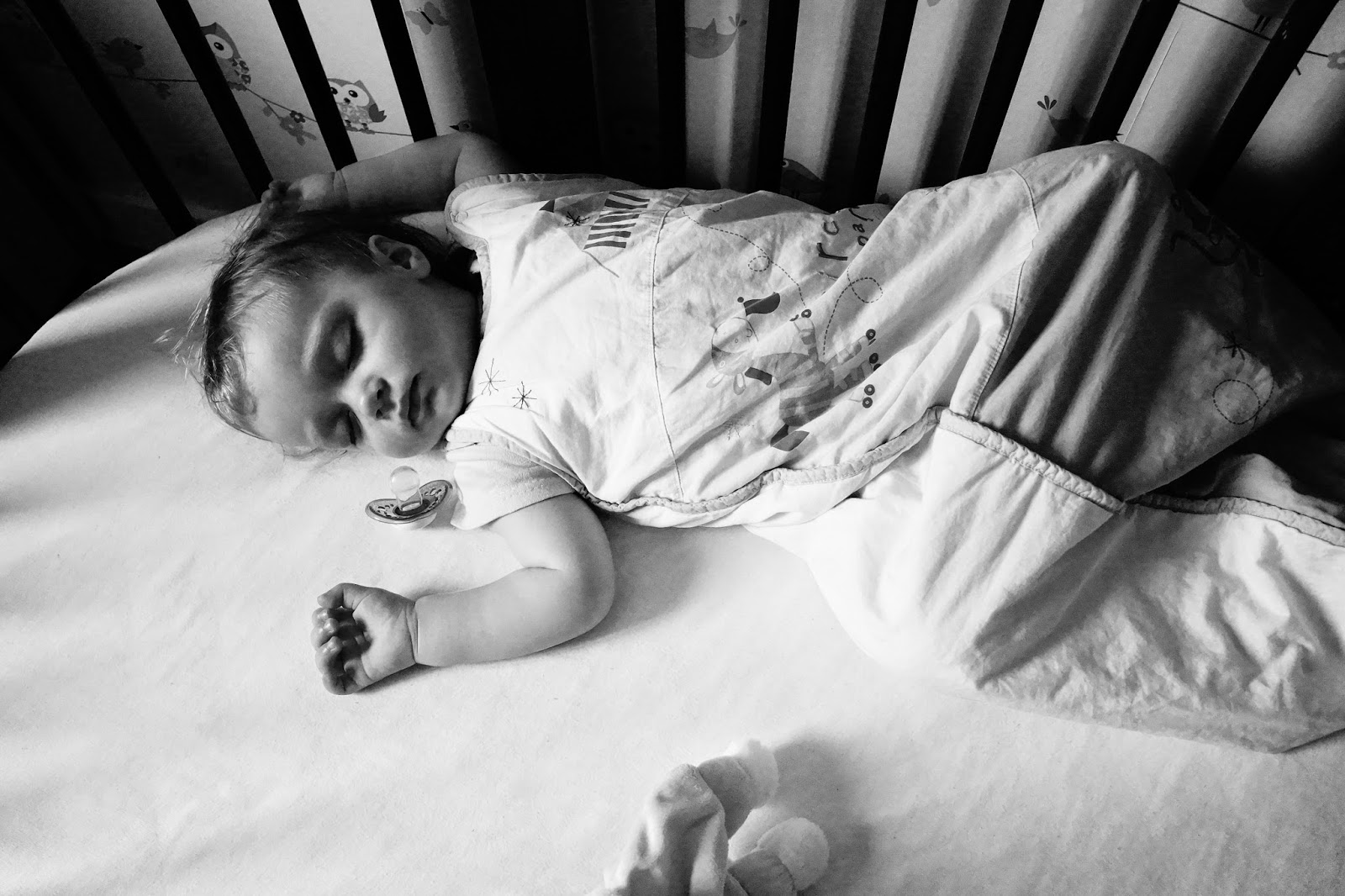 Black and white baby sleeping in cot