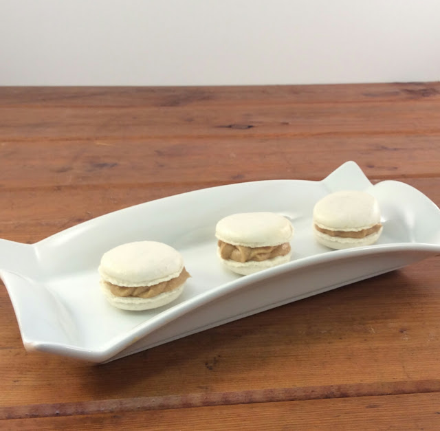 Salted Caramel macarons sitting on a white tray