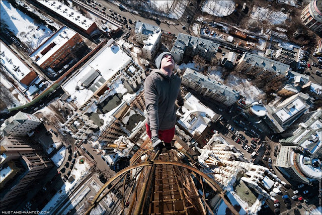 Man hanging from the steel ladders 