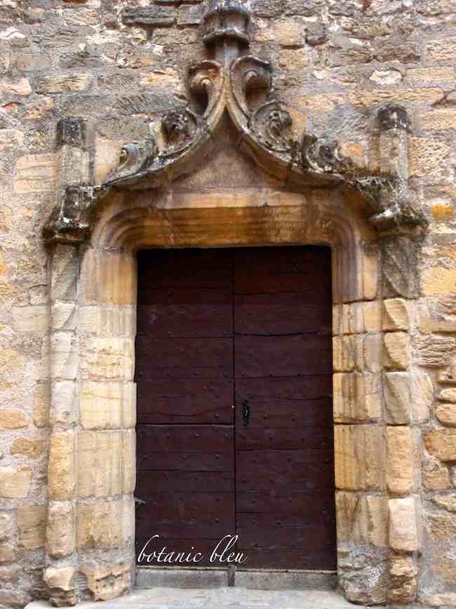 elaborate stone carved arch decorates a door in old city of Sarlat, France