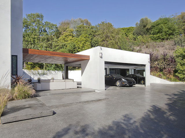 Photo of garage with the car connected to the house with terrace