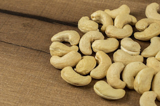 a pile of cashews on a wooden surface