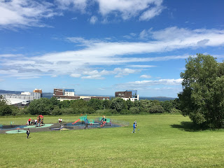 A playpark with tall buildings in the background.