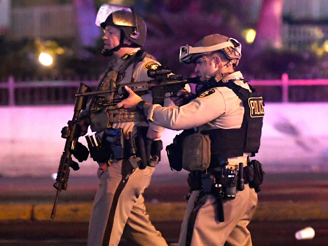 Police officers at the scene of the shooting, which saw dozens of people killed