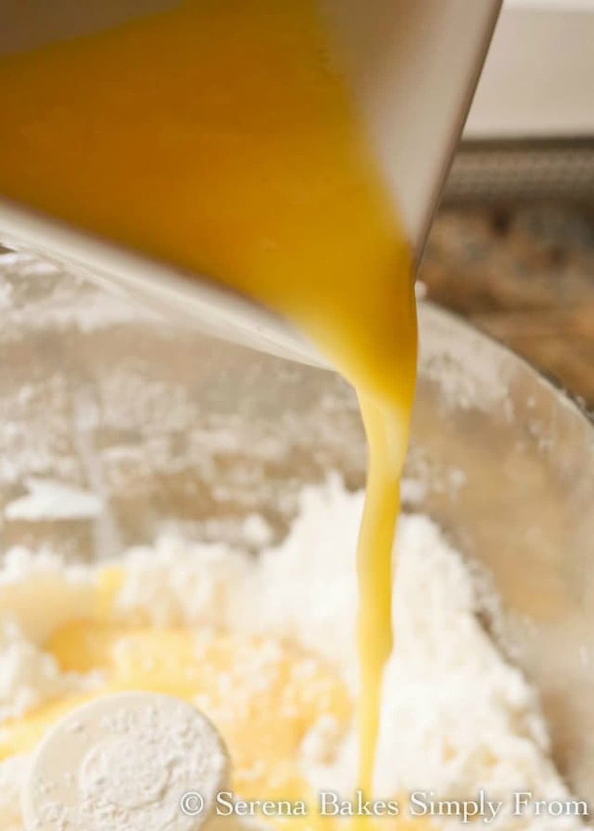 Egg mixture being drizzled into gluten free flour mixture in food processor.