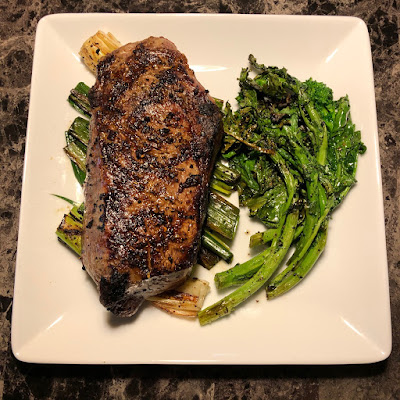 Rare New York strip with grilled leeks and broccoli rabe