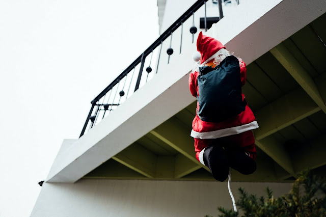 santa climbing down a balcony