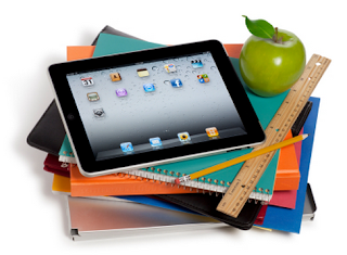 A stack of books and binders with a ipad on top