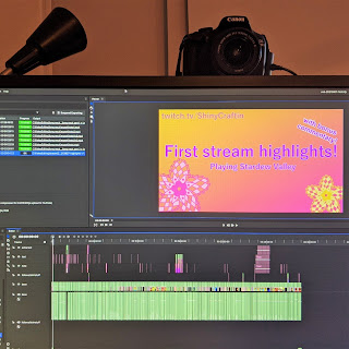 A computer monitor with Canon DSLR setup behind. The monitor has video editing software, Hitfilm Express open and exporting. The timeline at the bottom of the screen shows a heavily cut video.