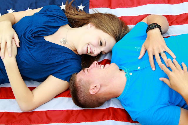 Husband and wife lying on an American flag