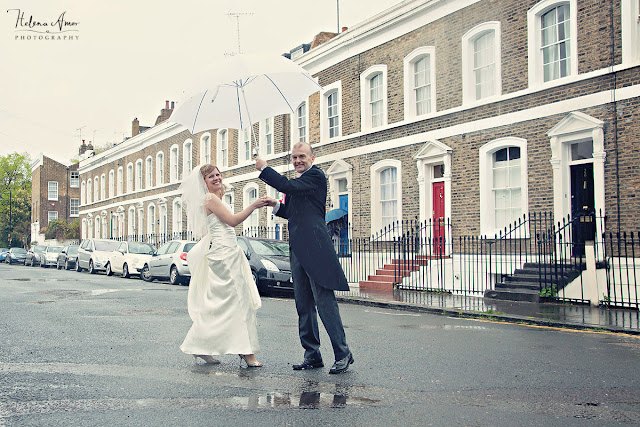 bride and groom dancing on the street with an umbrella at Islington wedding