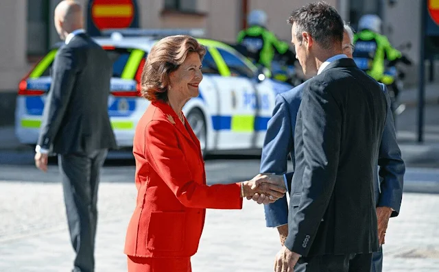 Queen Silvia wore a red blazer skirt suit. Gold necklace and gold brooch. Chanel shoes