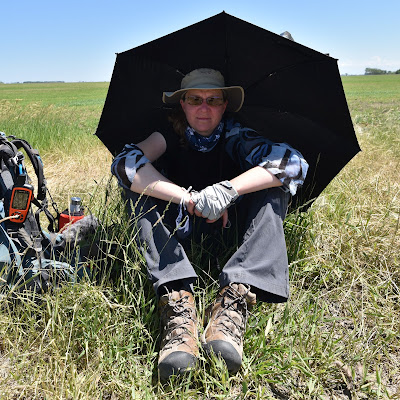 Sonya Richmond sheltering under sun umbrella in prairies on TCT.