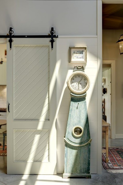 Sliding vintage barn door and Swedish mora clock - found on Hello Lovely Studio