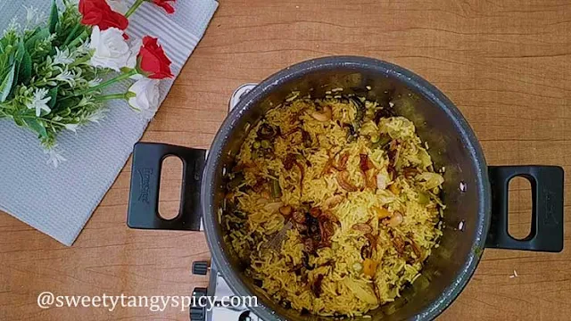 "Garnishing biryani with birista and ghee-fried nuts"