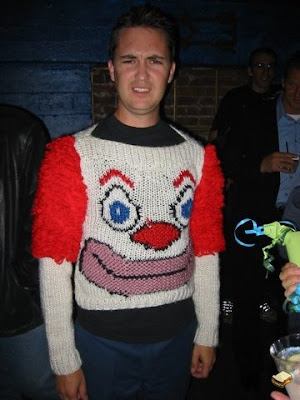 Wil Wheaton frowning while wearing a horrible red and white clown 
sweater