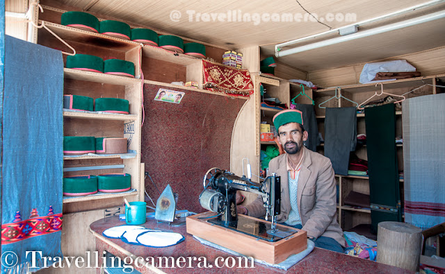 Recently some of us were on Kinnaur Trip and there is place called Jeory on the way. Sarahan is approximately 30 kilometers from Jeory and it's a beautiful town located on hill-top with amazing views of snow covered hills of Kinnaur. Bheemakali temple of Sarahan is most popular place to visit and this Photo Journey shares some of the moments spent around Bheema Kali Temple.Bheema Kali Temple has a huge campus and different temples inside the campus. There are two main temples, out of which one is accessible to everyone during normal days.The Second one is opened on some special occasions and Devi only allows Raja Virbhadra Singh to open the door of that temple. Shri Bheema Kali Temple is located in Sarahan town of Himachal Pradesh in India which is dedicated to the mother goddess Bhimakali, presiding deity of the rulers of former Bushahr State. The temple is situated about 180 km from Shimla and is one of 51 Shakti Peethass. The temple complex has another three temples dedicated to Lord Raghunathji, Narsinghji and Patal Bhairva Ji (Lankra Veer) - the guardian deity.Architecture of Bheema Kali Temple is beautiful. Whole campus is built with Stone and wooden blocks. It seems some part of the campus has not even cement to fix the joints. Whole campus is very well maintained and there is enough security as well.Here is one of the doors of the Bheem Kali temple in Sarahan Town. It's made up of silver with beautiful carving. There is also some text written, mostly in Hindi and Tibbatian scripts. Most of the carved forms are different gods and linked through some old stories.Sarahan was the capital of rulers of former Bushahr State. Bushahr dynasty earlier used to control the state from Kamroo. The capital of state later was shifted to Sonitpur. Later Raja Ram Singh made Rampur as the capital. It is believed that the country of Kinnaur was the Kailash mentioned in Puranas, the abode of Shiva. With its capital at Sonitpur this former princely state was extended up to entire area of Kinnaur where for sometimes Lord Shiva disguised himself as Kirata. Today, the then Sonitpur is known as Sarahan. Banasura, the ardent devotee of Lord Siva, eldest among the one hundred sons of great ablative demon King Bali and the great grandson of Vishnu votary Prahlad, during the Puranic age was the ruler of this princely state.(Courtesy - http://en.wikipedia.org/wiki/Bhimakali_Temple)According to a legend, the manifestation of the goddess is reported to the Daksha-Yajna incident when the ear of the Sati fell at this place and became a place of worship as a Pitha - Sthan. Presently in the form of a virgin the icon of this eternal goddess is consecrated at the top storey of the new building. Below that storey the goddess as Parvati, the daughter of Himalaya is enshrined as a divine consort of Lord SivaThere is a small market around Bheema Kali Temple and there are enough shops to have lunch or light snacks. Apart from that local caps can be bought from this fellow. He was very welcoming and offered good discounts for us :). We had asked for rates in Rampur Market, but he had better stuff and reasonable prices. There are many other shops in the town where some local stuff can be procured. On top of all that, most of the folks were really sweet to interact with.During our visit, we were looking for ladies wearing Dhaatu but couldn't gain the courage to ask anyone to get clicked by us. And just outside the Bheema Kali temple, this lady asked us to click one of her photograph and show her how we click. Probably she was noticing us clicking & reviewing photographs around the temple. We clicked few shots and showed to her. She shared some tips to improve and finally approved few of the shots. After final approval, she invited us to her hotel nearby but we couldn't go because it was time to head back as we had booked guest-house in Jeory.Here is a nearby sight, which is popularly known as Hawa-Ghar. This point has very clear view of Kinnar-Kailash Hills and place was quite windy. We spent around 30 minutes here to enjoy the breeze and take rest. This place is isolated form hustle bustle of the town. When we reached, there was only one person sitting here. Probably this place was least used by localites, as everyone has Hawa-ghar around their own houses :)Whole place was surrounded by Pine or Deodar Forests and smell was awesome in the middle of these forests. It was really an amazing experience to roam around Bheema Kali Temple and Sarahan Town. Meeting different people, visiting one of the amazing temples in this region, Hawa Ghar, a huge house of old kingdom etc.The town Sarahan is known as the gateway of Kinnaur. Down below at a distance of 7 km from Sarahan is the River Satluj. Sarahan is identified with the then Sonitpur mentioned in Puranas.Before entering into the main temple, everyone needs to lock mobiles, wallets or anything else which is made of leather and then wear a cap. Above photograph shows Aneesh wearing the holy cap and standing on right side of lockers everyone gets to keep everything safe. 