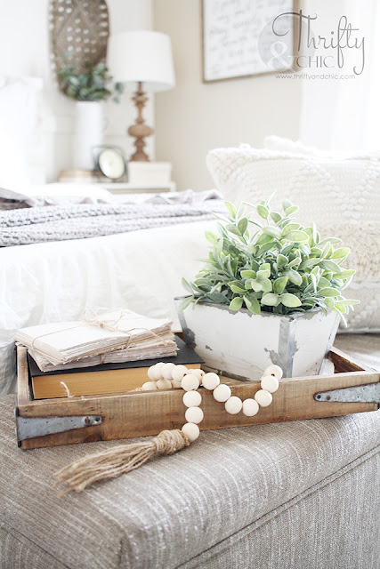 wood bead garland on tray with books and greenery