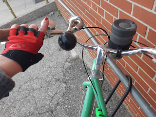 New cycling gear on my handlebars: red and black gloves, chrome bugle horn, black cupholder with black and grey cup