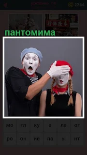  сделана пантомима мужчины в маске закрывающий рукой лицо женщины