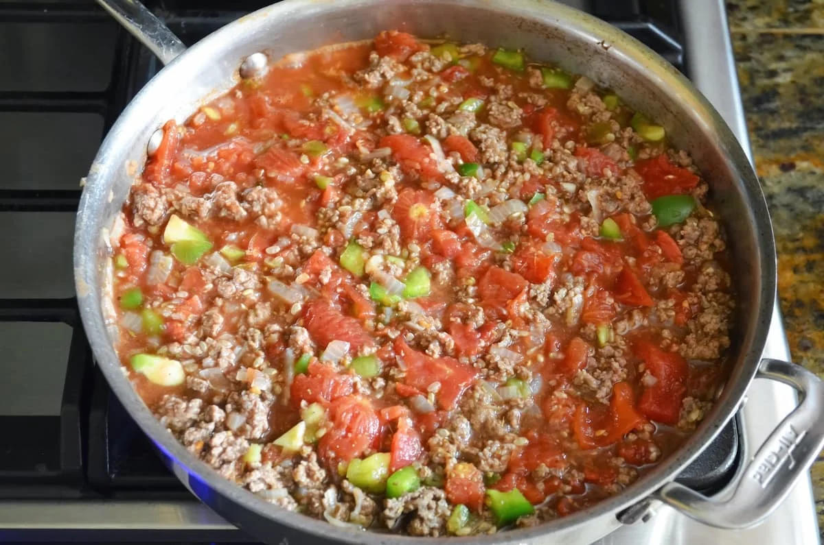 Stuffed Bell Pepper Ground Beef stuffing mixture simmering in a large stainless steel skillet.